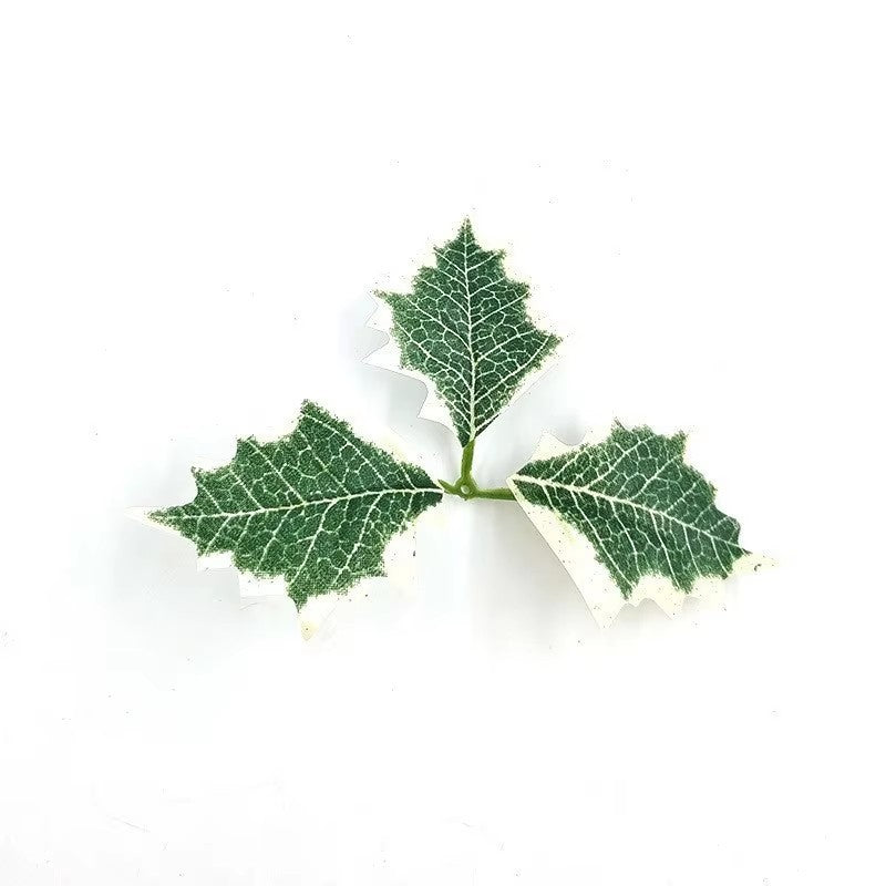 Weihnachtsblätter und rote Früchte als Christbaumschmuck